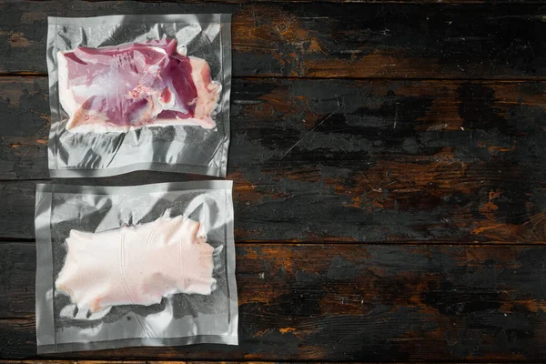 Raw duck breast in seal bag for sous vide cooking set, on old dark  wooden table background, with copyspace  and space for text