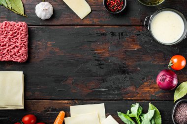 Boş Alan Temizleme Çerçevesi lazanya pişirme konseptini ayarladı. İtalyan Malzemeleri, lazanya çarşafları et bitkileri domatesler, beşamel sosu, eski koyu ahşap masa arkaplanı, üst görünüm, düz yatış, metin için kopya alanı
