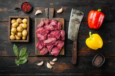 Tatlı dolmalık biber ve patatesli taze kesilmiş et seti, eski, siyah ahşap masa üzerinde, üst manzara düz yatıyordu