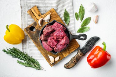 Çiğ organik et ya da kuzu eti tatlı dolma biberli, dökme demir tavada, beyaz taş yüzeyde, düz manzaralı