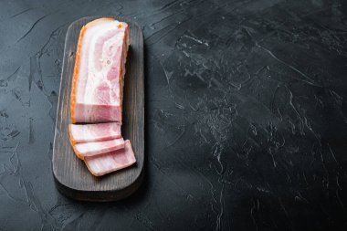 Pastırma pancetta kes ve siyah arkaplanda dilimle metin için boşluk bırak.