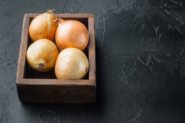 Siyah arkaplanda, metin için kopyalama alanı ile soyulmamış ham sarı soğan