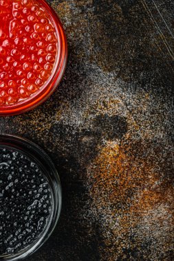 Kırmızı ve siyah havyar cam kasede, eski koyu kırsal arka planda, üst görünüm düz metin alanı için fotokopi alanı ile yatıyordu