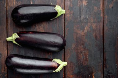 Taze organik patlıcan seti, eski koyu ahşap masa zemininde, üst görünüm düz yerde, metin için kopyalama alanı ile