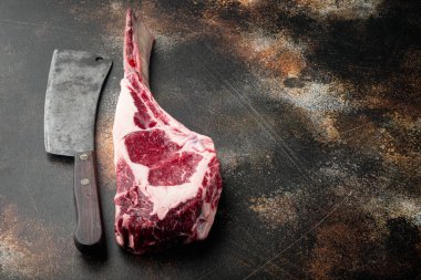 Tomahawk taze biftek ve baharatlar seti, ve eski kasap satır bıçağı, eski koyu rustik arka plan, metin için kopyalama alanı ile