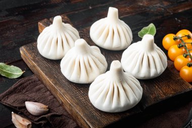 Pişmemiş Baozi Çin mantısı. Azian hamur tatlısı seti, eski, siyah ahşap masa arkasında.