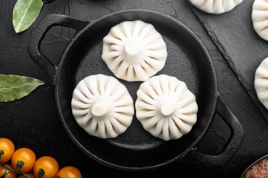 Manti, Türk geleneksel ravioli seti, kızgın demir tavada, siyah taş zemin üzerinde, üst manzara düz yatıyordu