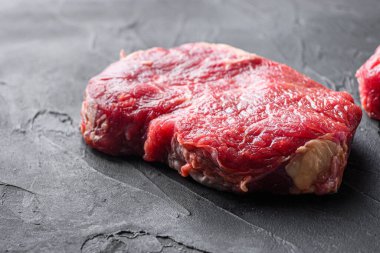 Organik etten alınmış çiğ biftek siyah desenli arka plan, kenar görüş.