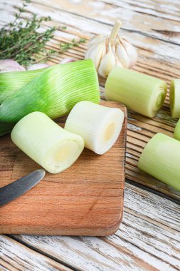 Choppong tahtasında yeşil doğranmış pırasa sultan beyaz ahşap masa manzarası seçici odak üzerinde