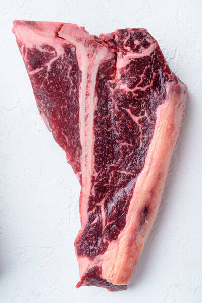 Стейк из кости сырой набор, на белом фоне из камня, вид сверху плоский лежал