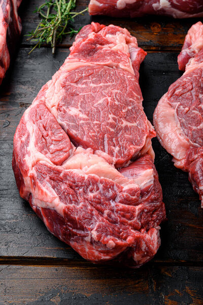 Raw marbled meat set, Rib eye cut, on old dark  wooden table background