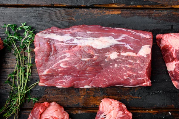 Çiğ biftek fileto Mignon biftek kesim seti, eski koyu ahşap masa arkaplanı, üst manzara düz yatıyordu