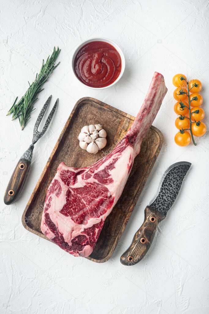 Tomahawk beef steak raw set, with seasoning and herbs, on white stone  background, top view flat lay