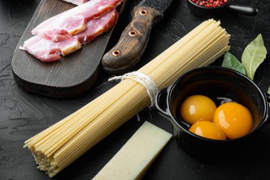 Carbonara makarna malzemeleri seti, siyah taş arka planda.