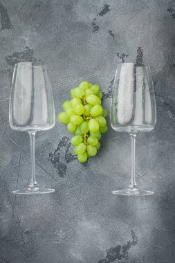 Üzüm seti olan şarap kadehleri, gri taş zemin üzerinde, üst görünüm düz yatay, metin için kopyalama alanı ile