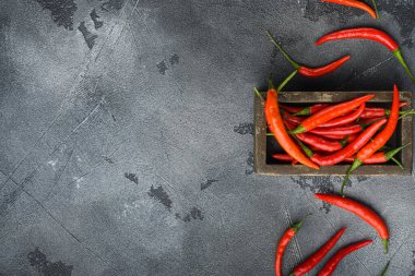 Taze mahmuz biber seti, ahşap kutuda, gri taş zemin üzerinde, üst görünüm düz, metin alanı için kopyalama alanı ile