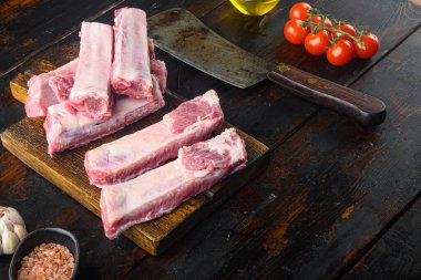 Biberiye setiyle taze domuz kaburgası, eski kasap bıçağı, eski siyah ahşap masa üzerinde, metin için kopyalama alanı ile