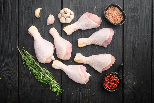 Fresh chicken meat cuts Farm poultry meat set, with seasoning and herbs rosemary and thyme, on black wooden table background, top view flat lay, with copy space for text