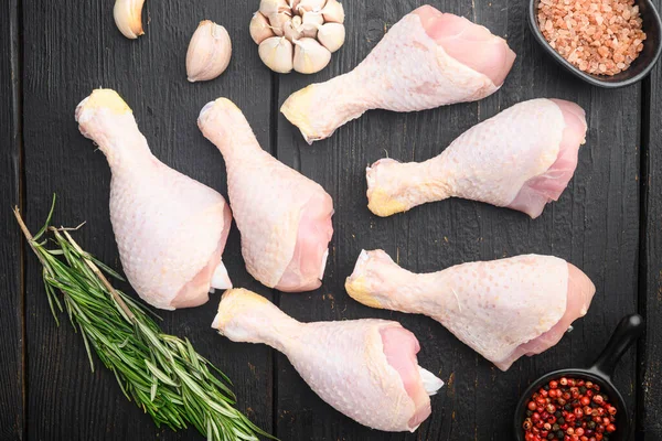 Fresh chicken meat cuts Farm poultry meat set, with seasoning and herbs rosemary and thyme, on black wooden table background, top view flat lay