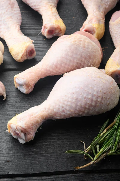 生の鶏の肉の切り身 太もも 翼と足をセット 調味料やハーブローズマリーとタイムと 黒の木製のテーブルの背景に — ストック写真