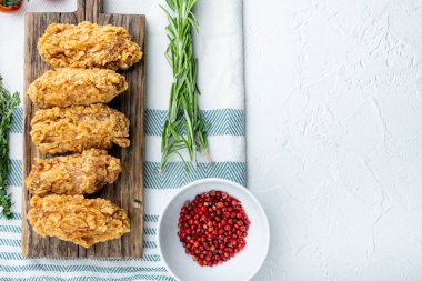 Beyaz arkaplanda, üst görünümde, kopyalama alanı olan kızarmış tavuk kanadı kesimleri.