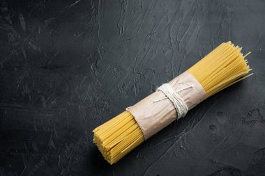 Uzun spagetti. Siyah arkaplanda, metin için metin alanı ve boşluğu olan ham spagetti seti