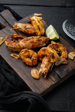 Izgara kırmızı Arjantin karidesleri ahşap tahtada, ahşap masa arkasında deniz ürünleri pişiriyorlar.