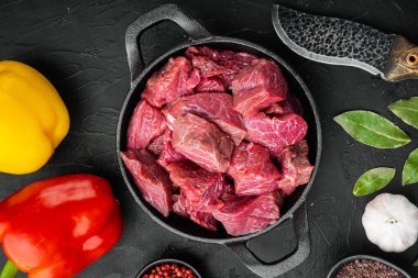 İrlanda usulü çiğ et güveci tarifi. Tatlı dolma biberli, dökme demir tavada, siyah taştan arka planda, düz manzaralı.