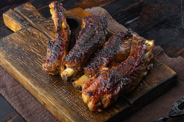 Barbecue pork spare ribs with fruit relish set, on wooden serving board, on old dark  wooden table background