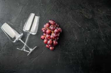 Üzümlü şarap kadehleri, siyah taş zemin üzerinde, üst görünüm düz yatay, metin için kopyalama alanı ile