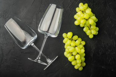 Üzümlü şarap kadehleri, siyah taş zemin üzerinde, üst görünüm düz yatıyordu