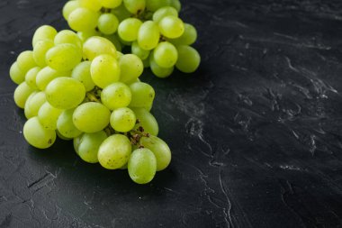 En iyi doğal üzüm demeti seti, yeşil meyveler, siyah taş zemin üzerinde, metin için kopyalama alanı ile