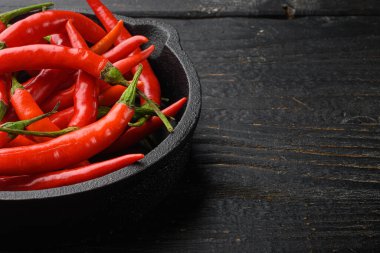 Siyah ahşap masa üzerinde sıcak kırmızı thai biber seti, metin için kopyalama alanı ile