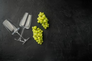 Üzümlü şarap kadehleri, siyah taş zemin üzerinde, üst görünüm düz yatay, metin için kopyalama alanı ile