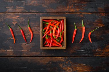 Olgun Cayenne biber seti, ahşap kutuda, eski siyah ahşap masa üzerinde, üst görünümü düz, metin alanı için kopyalama alanı ile