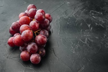 Üzüm meyvelerini parlat, koyu kırmızı meyveler, siyah taş zemin üzerinde, metin için kopyalama alanı ile