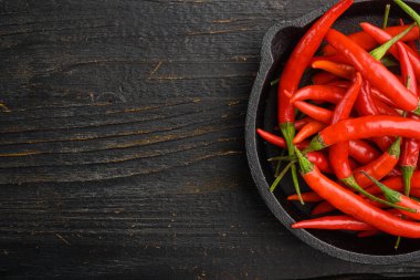 Chili spur biber seti, siyah ahşap masa, üst görünüm düz yatay, metin için kopyalama alanı ile