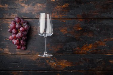 Üzüm seti olan şarap kadehleri, eski koyu ahşap masa üzerinde, üst görünüm düz yatay, metin için kopyalama alanı ile