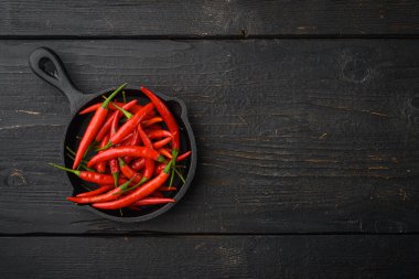 Olgun Cayenne biber seti, siyah ahşap masa, üst görünüm düz yatay, metin için kopyalama alanı ile