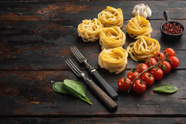 Malzeme seti ile makarna tagliatelle, eski koyu ahşap masa arkaplanı, metin için kopyalama alanı ile