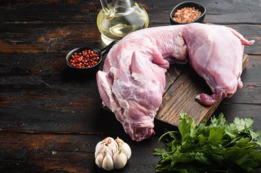 Taze sebzeli çiğ tavşan eti, otlar ve baharatlar, eski siyah ahşap masa zemininde, metin için kopyalama alanı ile