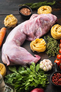 Tavşan güveci tagliatelle malzemeleri seti, eski koyu ahşap masa arka planında.