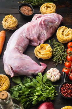 Tagliatelle güveç seti için baharatlı ve sebzeli çiğ et, eski siyah ahşap masa arka planında.