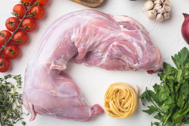 Taze et. Tavşanın tamamı yahni pişirmeye hazır. Tagliatelle seti, beyaz taş arka planda, düz manzaralı.