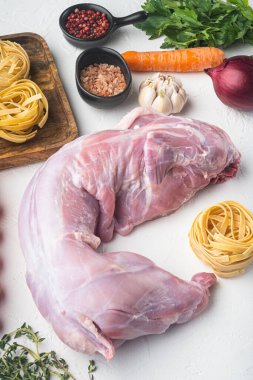 Taze sebzeli çiğ tavşan ve tavşan yahnisi için makarna, beyaz taş arka planda.