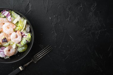 Geleneksel Waldorf salatası kereviz, karides seti, elma sosu ve üzüm, siyah taş zemin üzerinde, üst görünüm düz, metin için kopyalama alanı