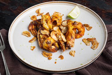 Izgara mango karides ya da karides seti, tabakta, eski, siyah ahşap masa arka planında