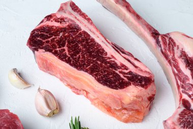 Beyaz taştan arka planda, çiğ et seti.