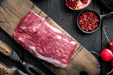 Baharatlı çiğ biftek fileto bifteği ve tüm mermer fileto kesim seti, siyah ahşap masa arka planı, üst düz manzara