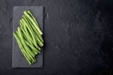 Yeşil fasulye seti, taş tahtada, siyah zemin üzerinde, üst görünüm düz yatay, metin için kopyalama alanı ile